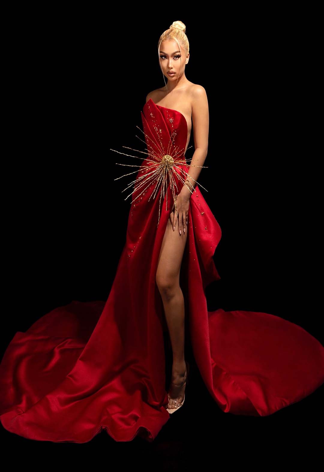 Red satin strapless gown with gold metal star attached to a ribbon belt and bursting-effect celestial bead work