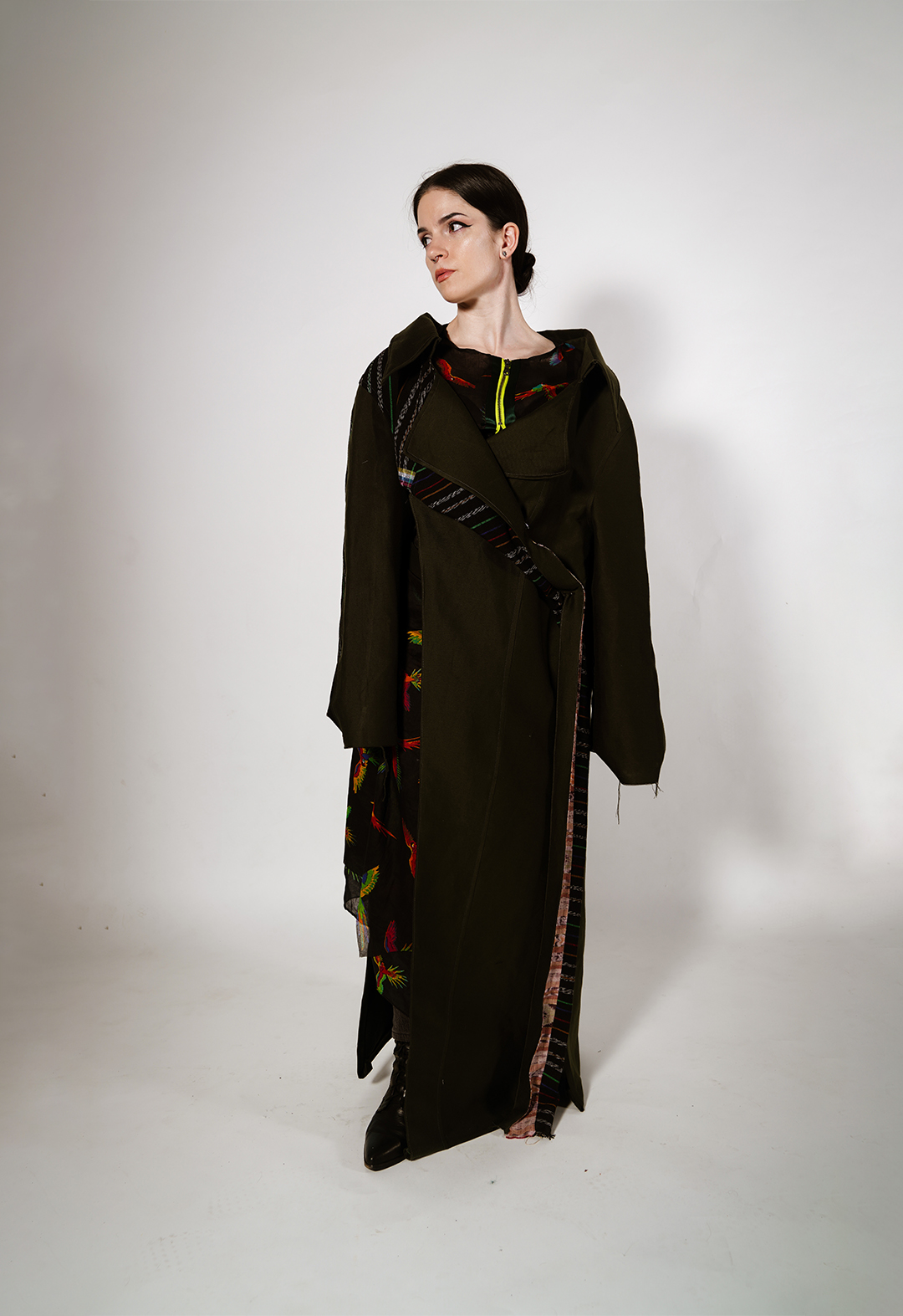 This is a colorful artisanal Mayan textile deconstructed trench and matching skirt in army-green silk wool. I draw from the vibrant textiles of Guatemala to create pieces that represent the strength and cultural identity of the Mayan people amid the dissolution of their homelands.