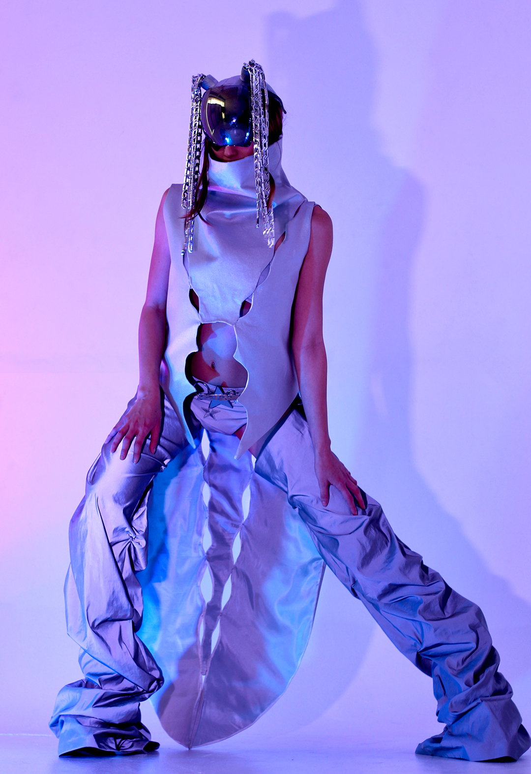 With purple hue lights, Sonja wears the main look of this collection; The Astral suit! With metallic fabrics, this look is reflective and shines when it hits the lights. Topped off with the 3D-printed Astral helmet with chain ponytails!