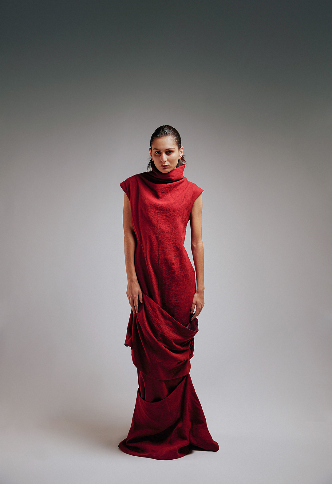 Look 1 is draped in textured burgundy crepe, showing beautiful drapes of the dress with custom stitching in the middle and sides. 