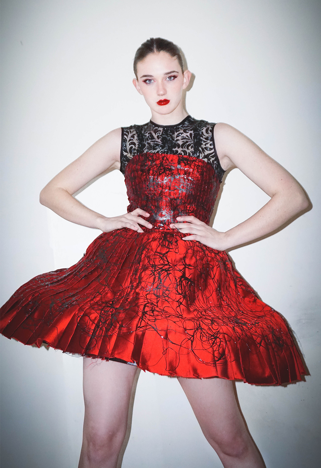 Front view of the model wearing a hand-pleated silk wool skirt with upcycled 3D-printed cage crinoline and 3D-printed lace mesh.
