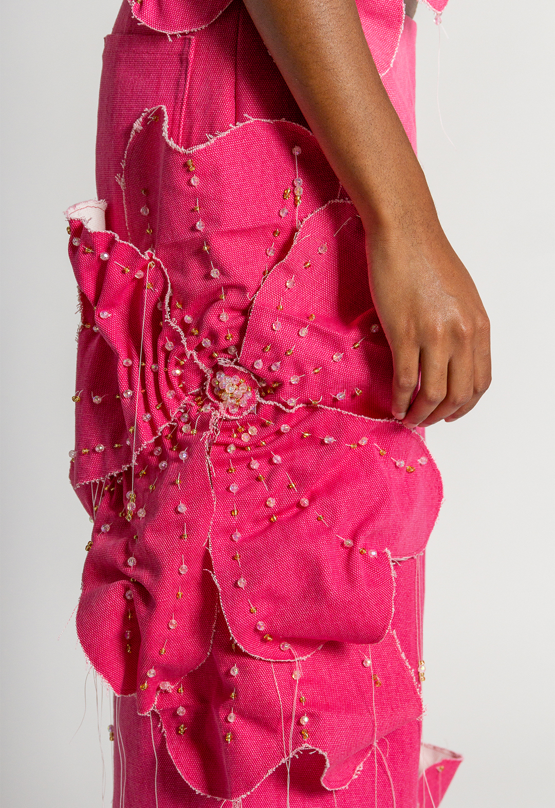 Right leg pants side view: Embellished flower with gold and iridescent pink beads.