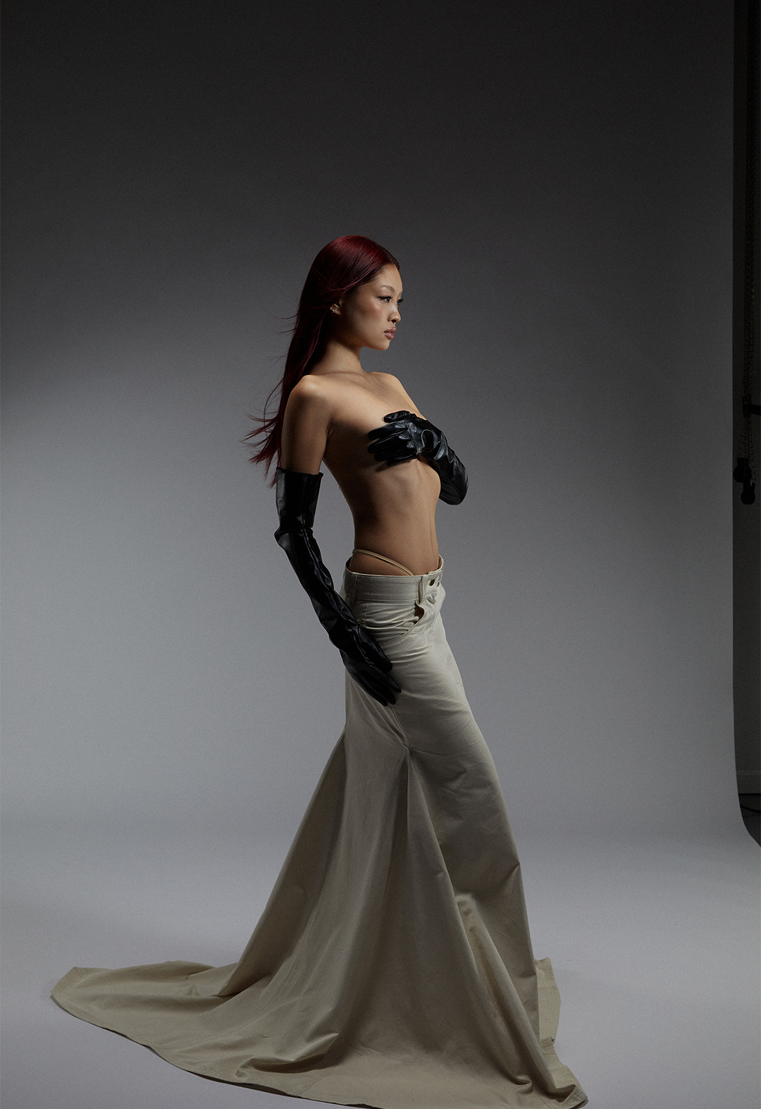The photo shows a side view of a model wearing a denim maxi skirt.