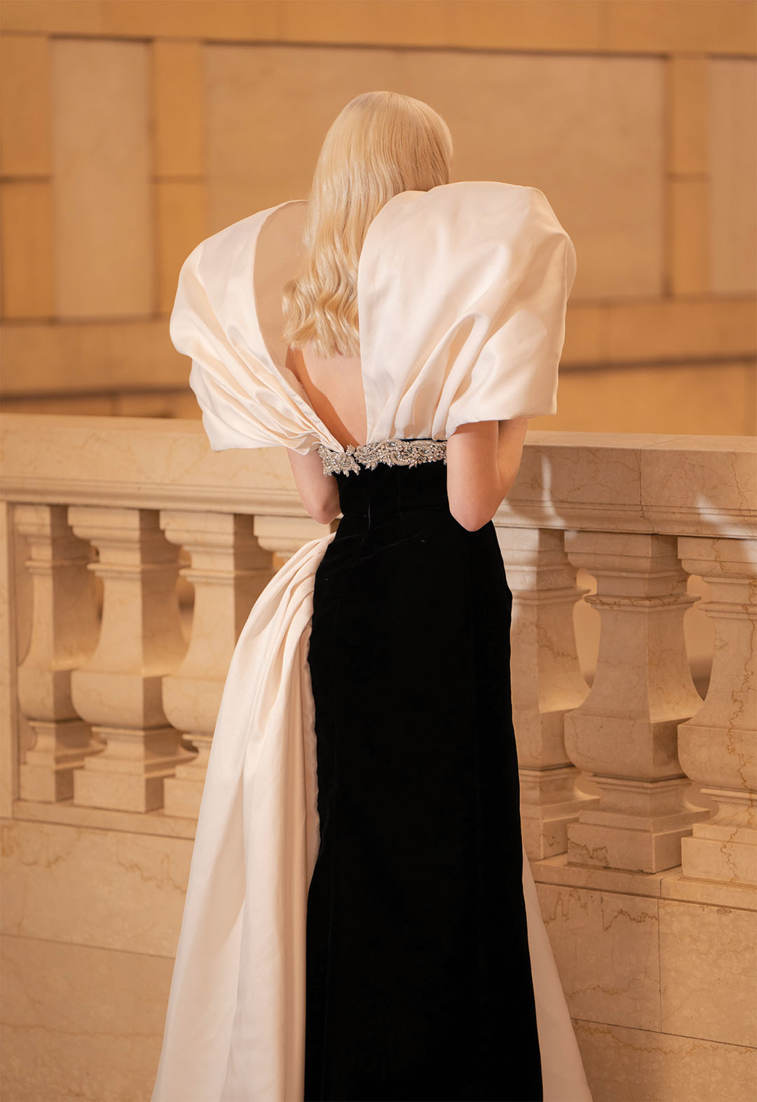This image is the back of the dress. Unlike the front part, it boldly shows the back of the model to show the beauty of the reversal. The crystal decoration extends to the back, showing a couture aspect.