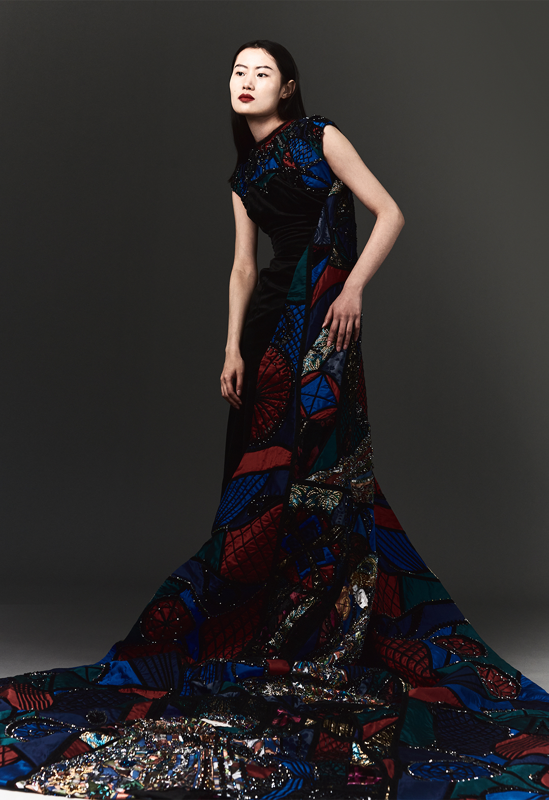 Side-profile shot of a model wearing a stained glass cape, velvet gown.