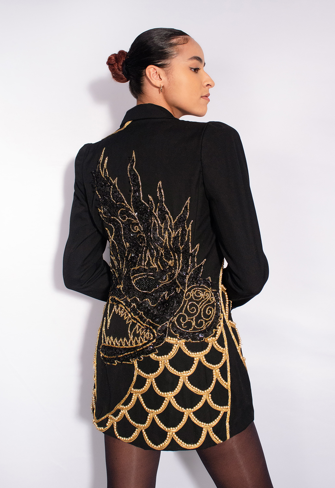 The back view of the jacket shows the head of the Naga that is fully beaded with gold seed beads. The inside of it is filled with black sequin trim. The head is connected to the neck, which is filled with scales made out of gold metallic trims and glass pearls.