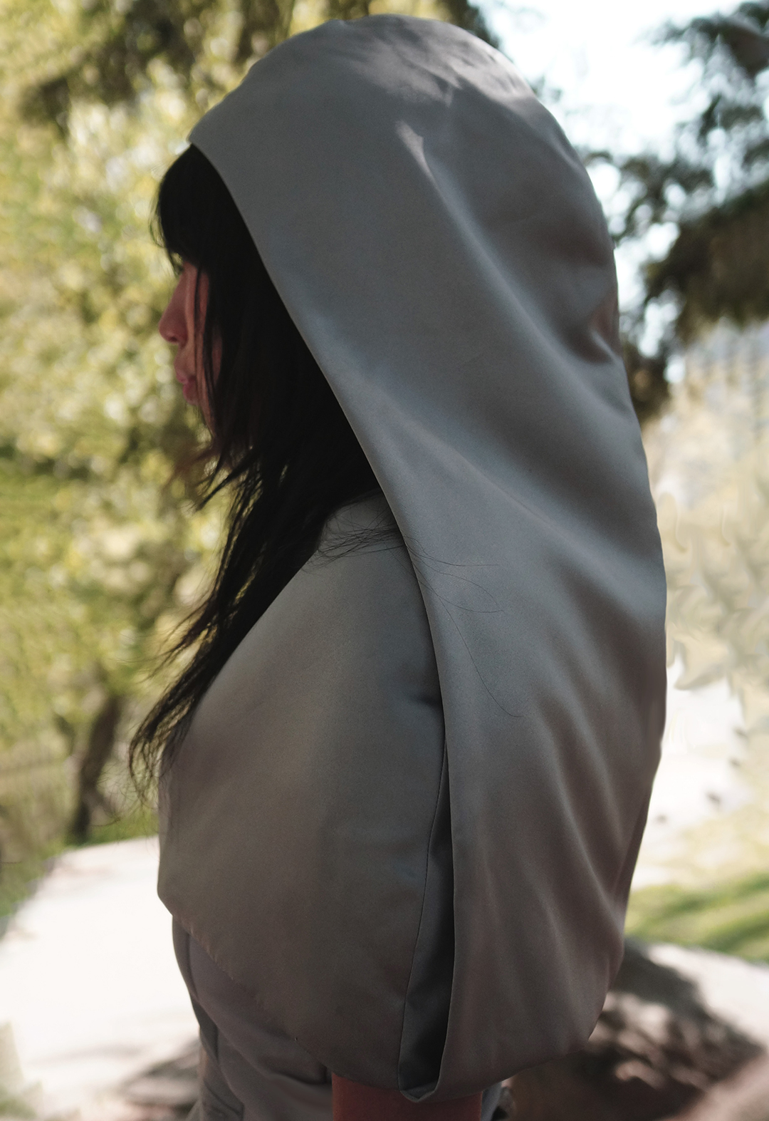 This is a close-up side view of a model wearing a curved gray hood.