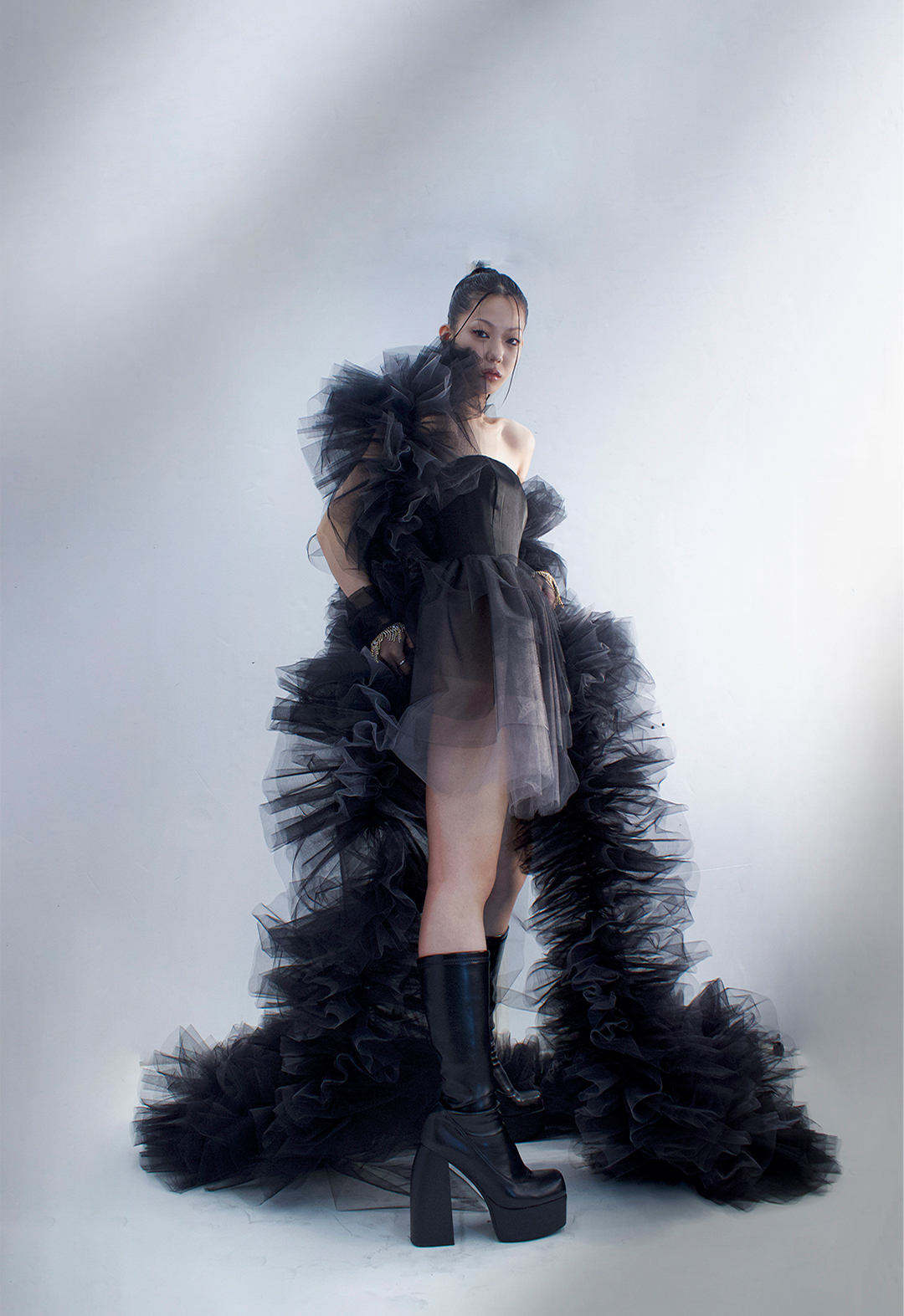 Side view of the look. The look features black tulle gloves with gold rhinestone fringe detailing.  