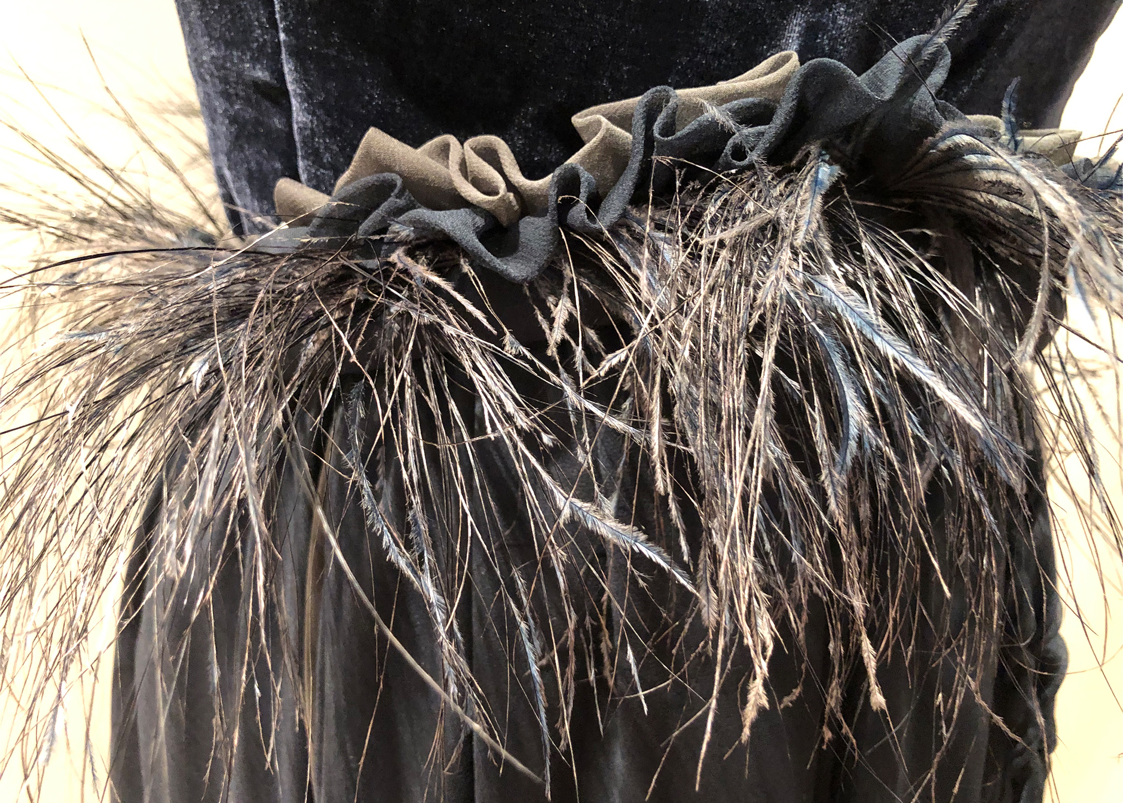 Close up view of an ostrich feather trim on the waist of the gown.