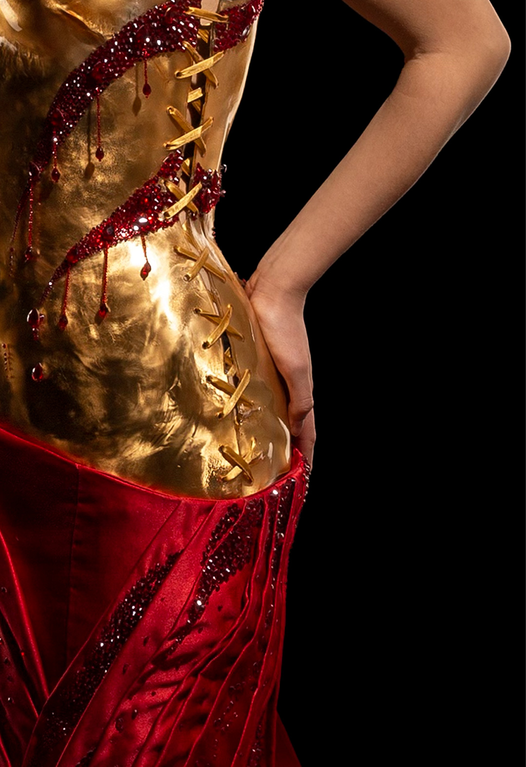 The left side view of the dress shows the imitation lace-up of the dress, with gold lace giving it a corset look. The scars from the front are carried to the back. The pleated skirt continues the dripping-blood effect with rhinestone details.