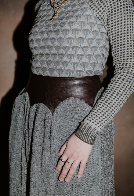 Close-up shot of domed leather yoke of knit skirt and Islamic architecture–inspired top with rib sleeve cuff.