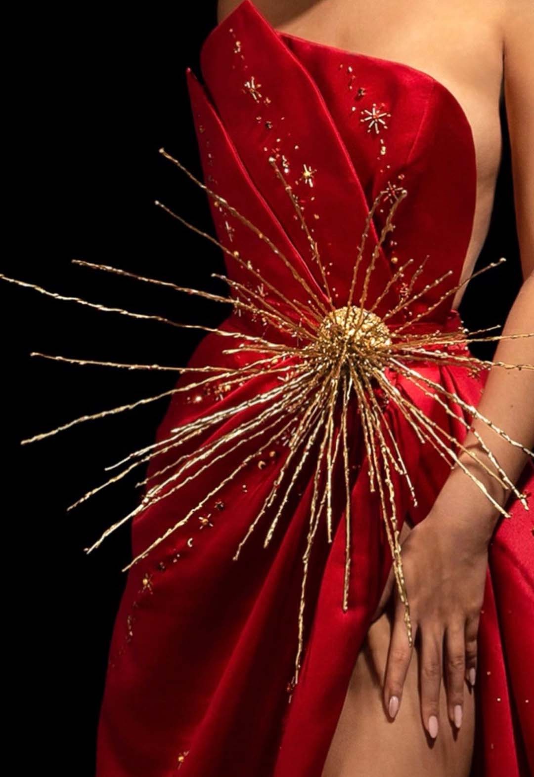 Beaded gold metal star represents an atomic star with variety of beads bursting out throughout the pleats and along the bodice.