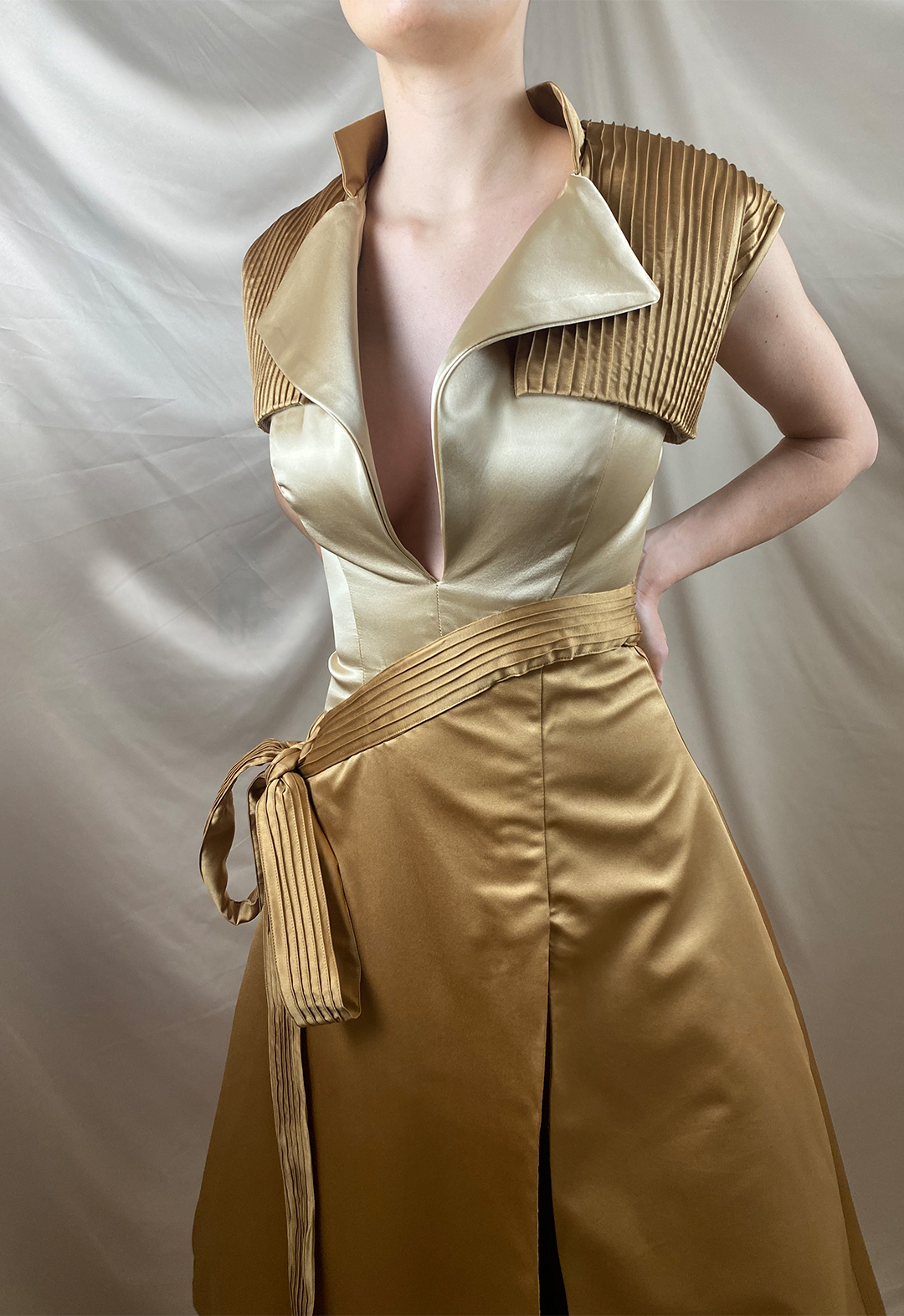 Front close-up shot of the garment. A notched collar bodice with a low neckline and a pin-tucked vest can be seen.