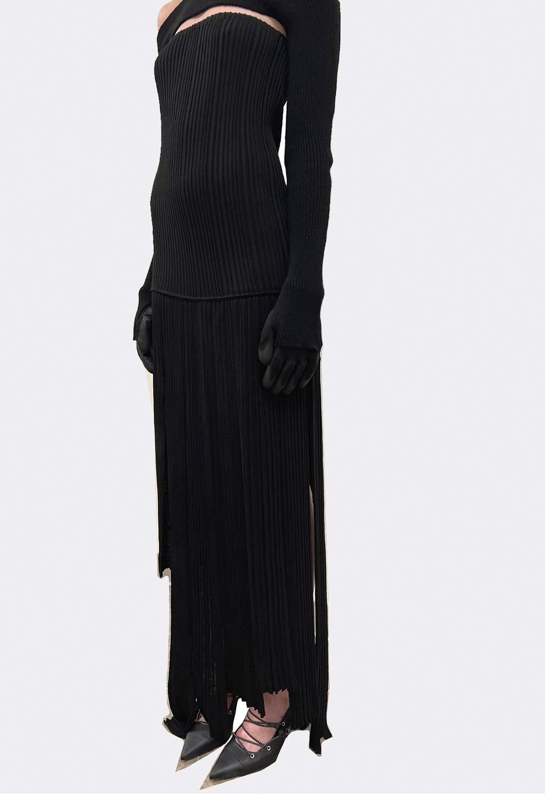 Three-quarter view of a model wearing a black knit dress.