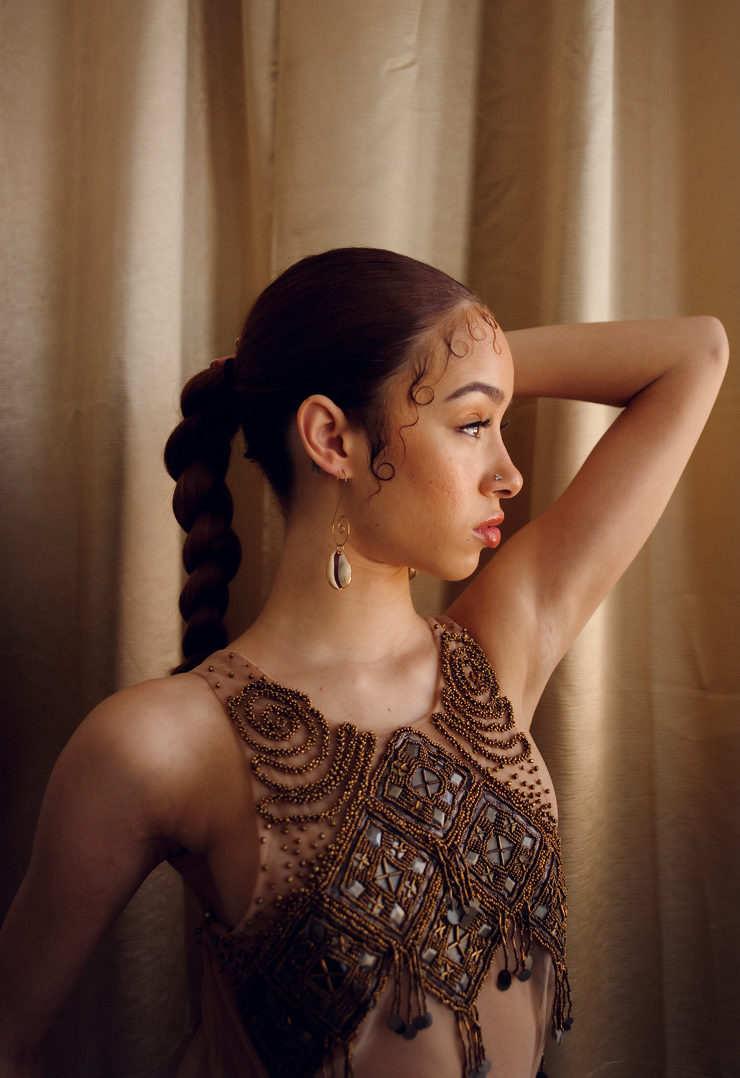 Close up shot of a model wearing a brown embellished gown.