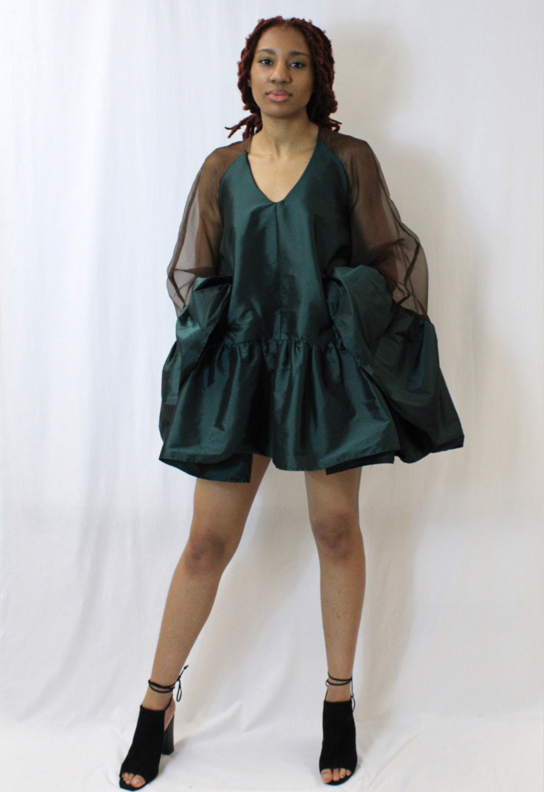 The images shows a voluminous tent dress with ruffles continuously around the body and sleeve hem. 