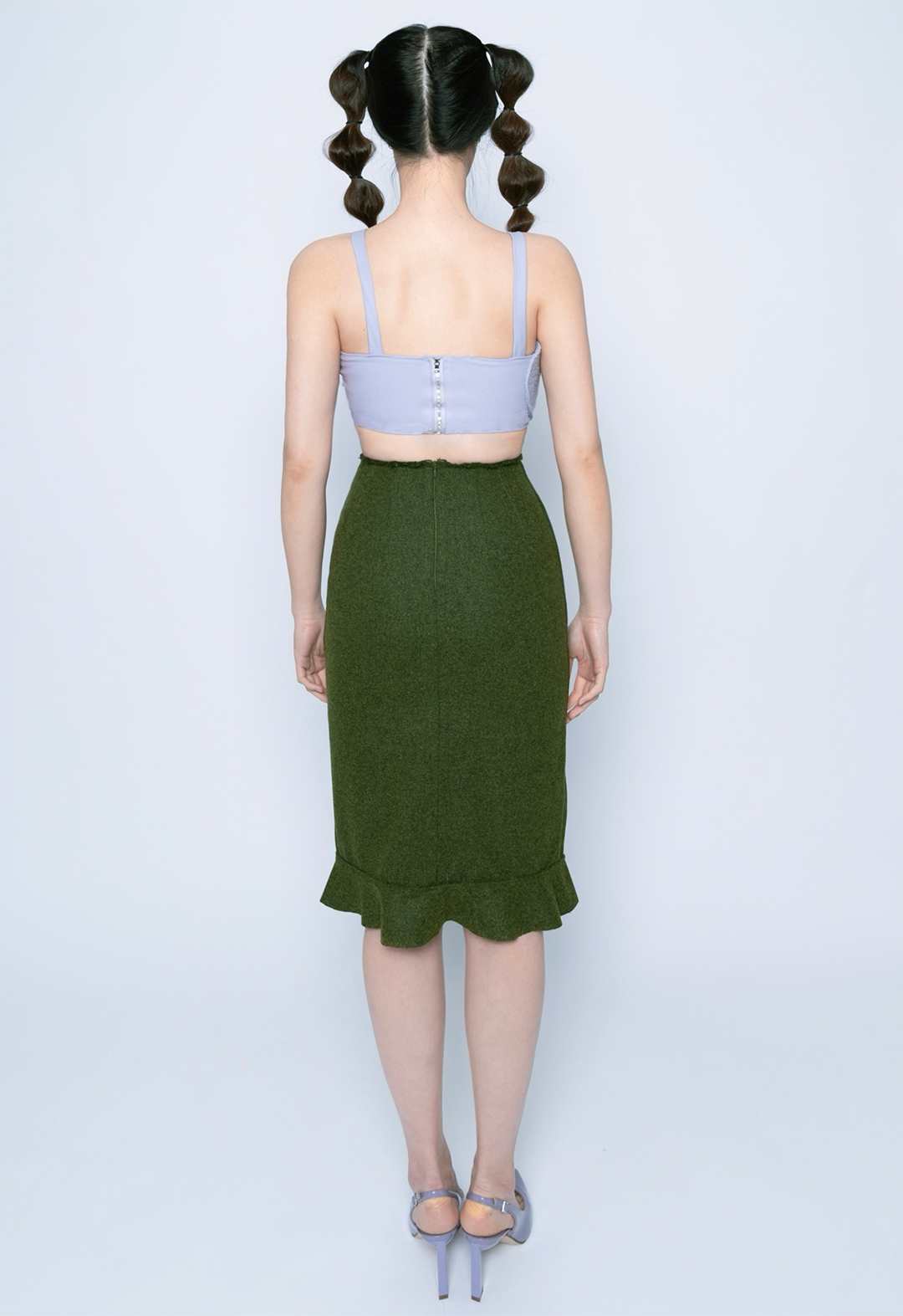 The image shows a back view of the crop top with zipper at the center back, top stitch with rough edge at waist for skirt, and a connecting ruffle with flat felled seam at the hem. 