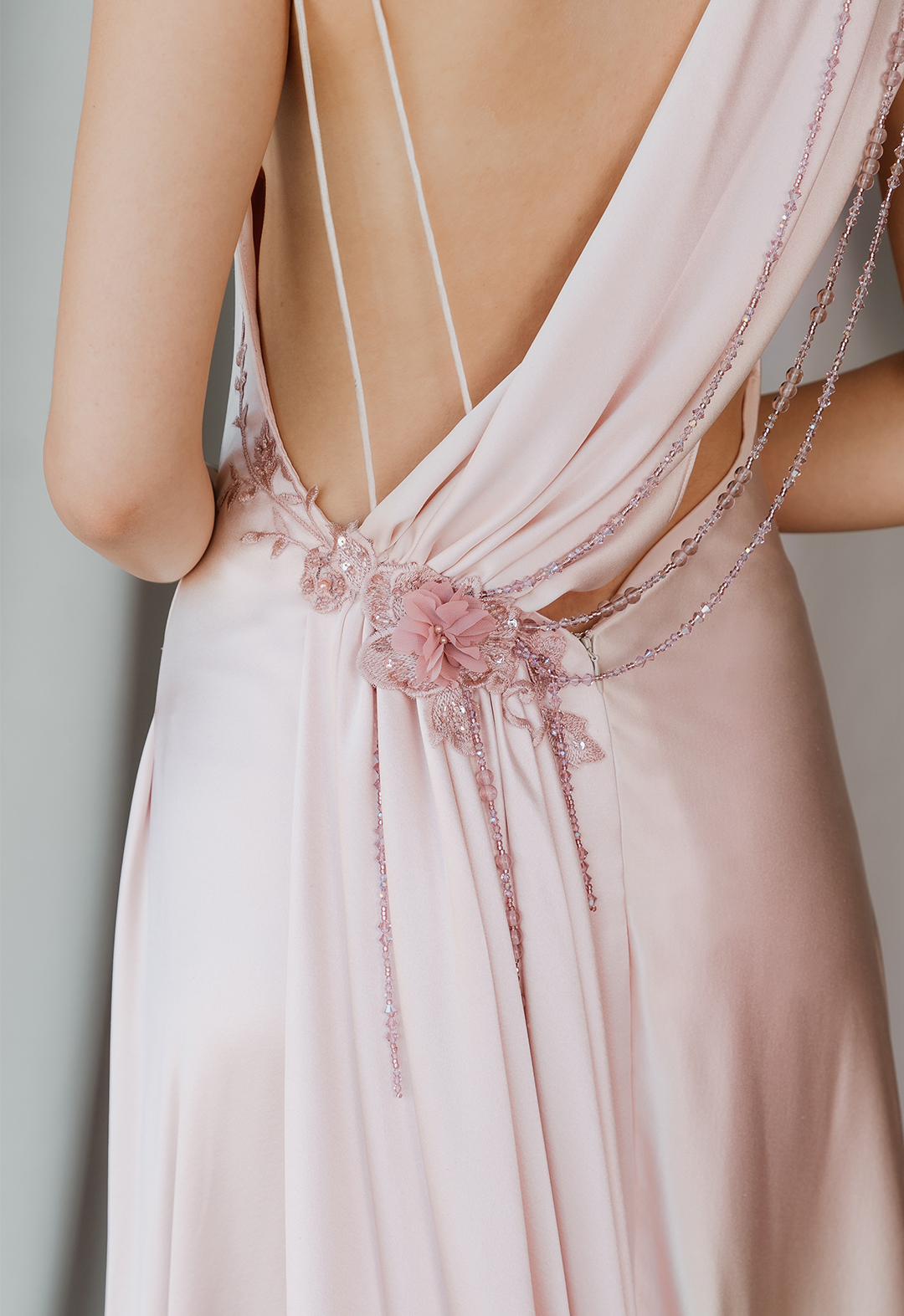 Back detail of blush silk crepe back satin bias dress. Dress features Swarovski crystals and lace appliqué.  
