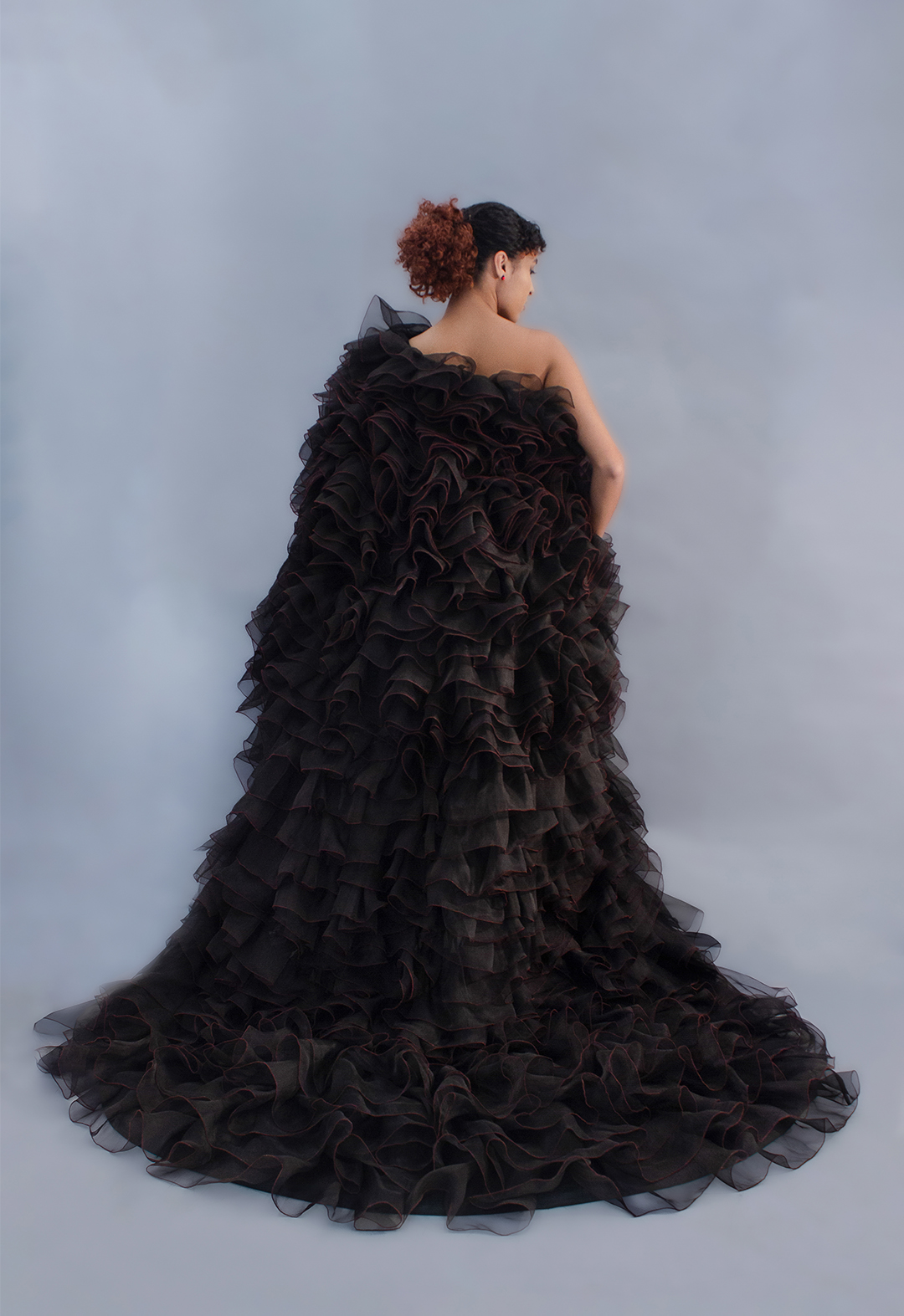 The back of the dress has a train with ruffles ranging in size from small to big. 