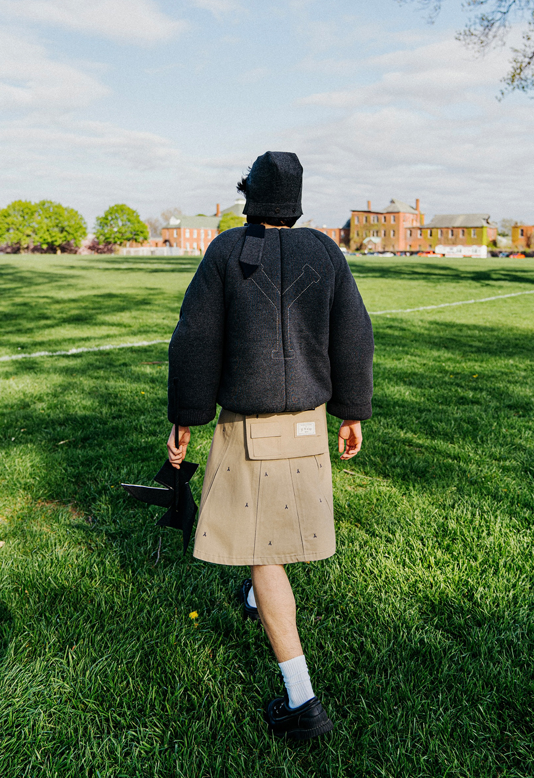 The photo shows a back view of a model walking into a field.